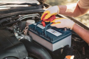 auto mechanic repairs a car. A mechanic removes a car battery from the box. auto mechanic repairs a car. A mechanic removes a car battery from the box.